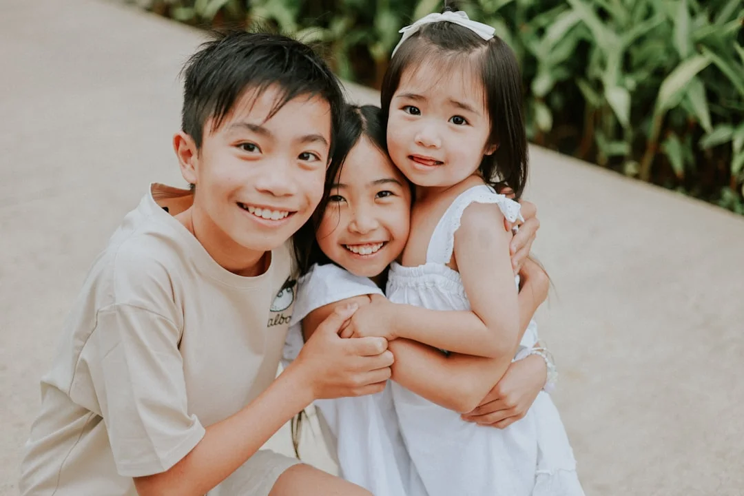Three happy children hugging and smiling